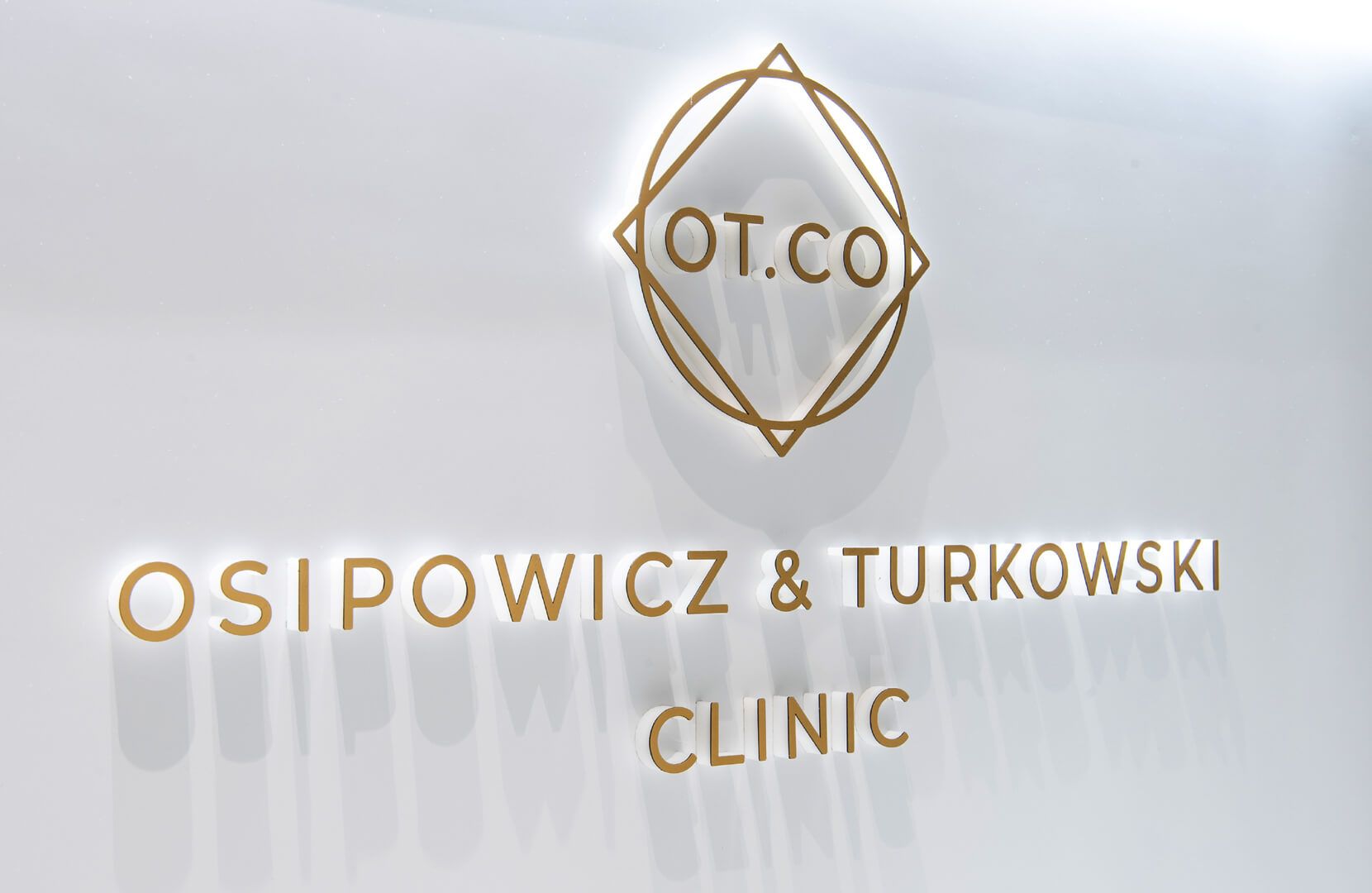 Ruimteletters in de ontvangstruimte van OT.CO Clinic - Gouden ruimtelijke letters met logo in de ontvangstruimte van OT.CO Clinic